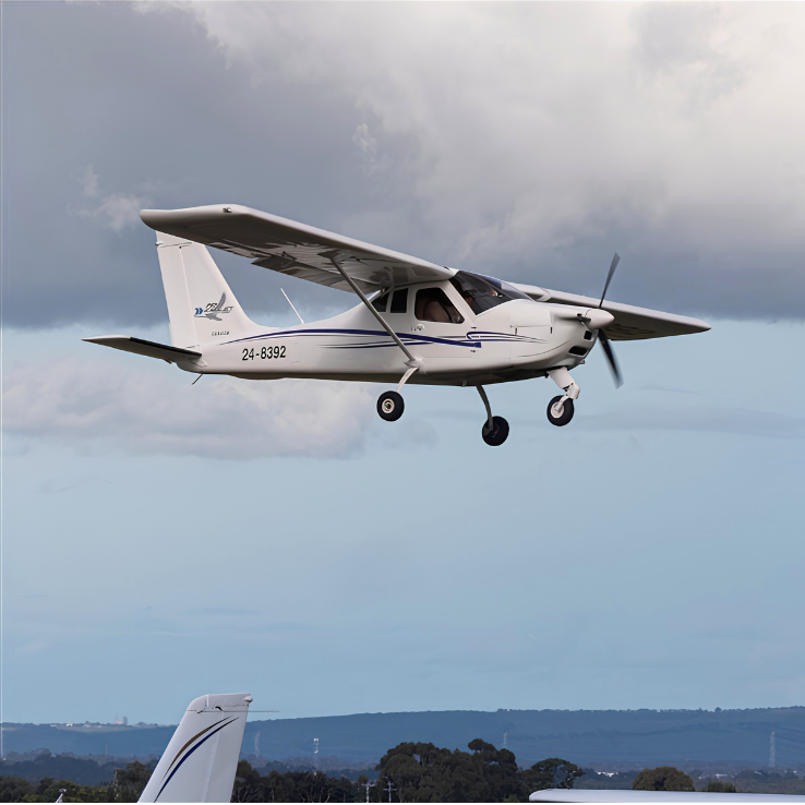 Small airplane flying against a blue sky with white clouds
